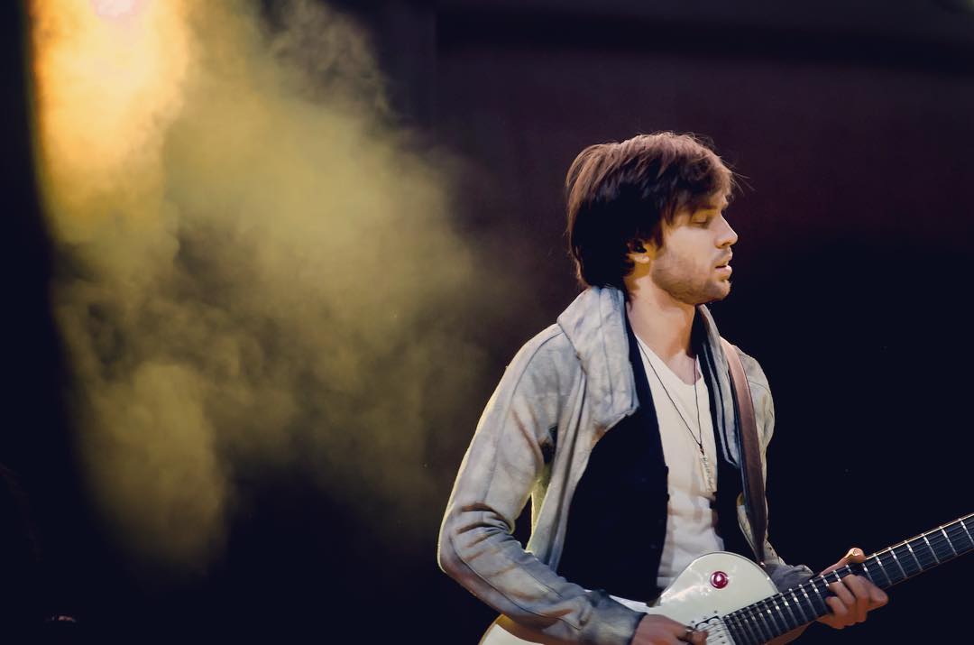 Tyler playing guitar in golden light