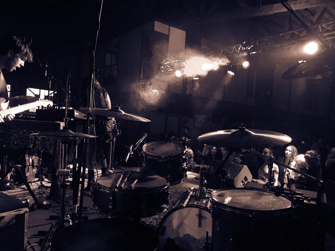 Behind the drum kit on stage